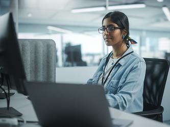 young woman working at a computer screen in office